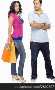 Young woman holding shopping bags with a young man standing beside her