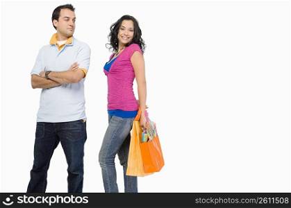Young woman holding shopping bags with a young man standing beside her