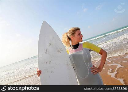 Young woman holding surfboard at the beach