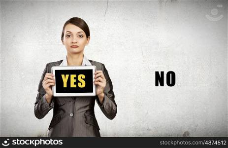 Young woman holding tablet pc with word yes. Yes or no
