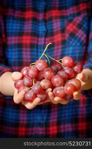 Young woman holding tasty grapes