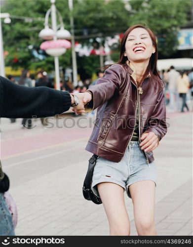 Young woman holding the hand of another person