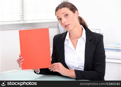 Young woman holding up a red file