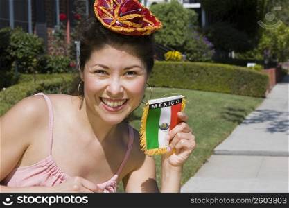 Young woman holding up Mexican flag