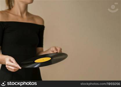 young woman holding vinyl disk with copy space