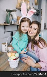 young woman hugging daughter bunny ears