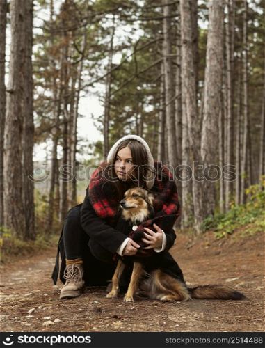 young woman hugging her dog forest
