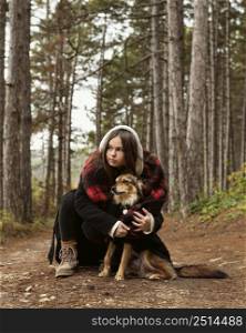 young woman hugging her dog forest