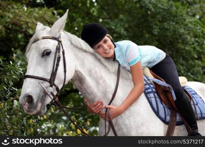 Young woman hugging her horse