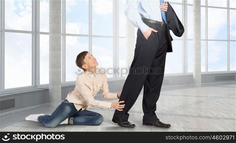 Young woman hugging husbands leg and asking not to go