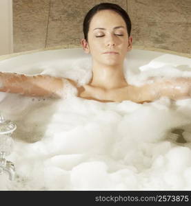 Young woman in a bathtub with her eyes closed