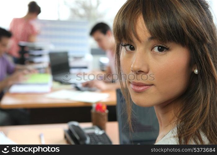 Young woman in a busy office