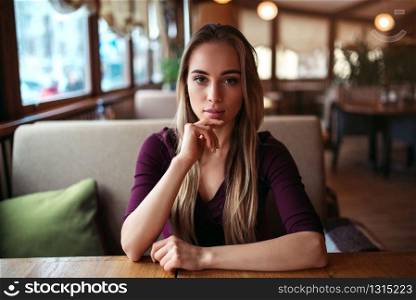 Young woman in a cafe or restaurant. Female waiting in cafe.. Woman in a cafe or restaurant