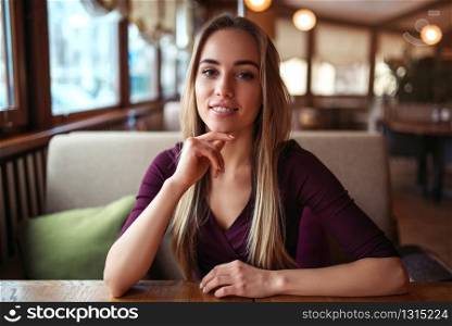 Young woman in a cafe or restaurant. Female waiting in cafe.