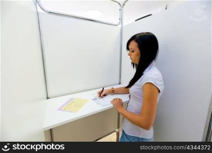 young woman in a polling booth on voting.