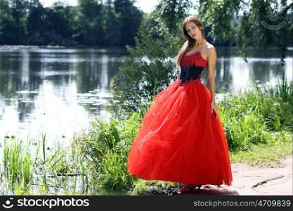 Young woman in a red gothic dress