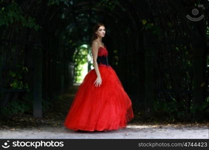 Young woman in a red gothic dress