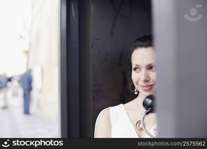 Young woman in a telephone booth