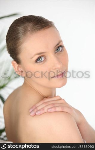 Young woman in a towel looking over her shoulder