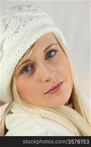 Young woman in a white knitted hat and scarf