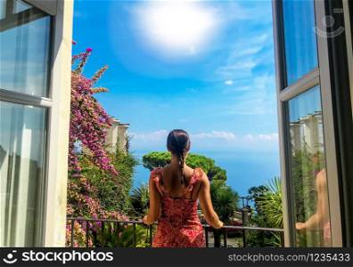 Young woman in balcony looks at wiew of famous Amalfi Coast with Gulf of Salerno from Villa Rufolo gardens in Ravello, Campania, Italy, 2019. Women, one woman Travel destinations in Europe, Italy.