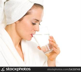 Young woman in bathrobe drinking pure water