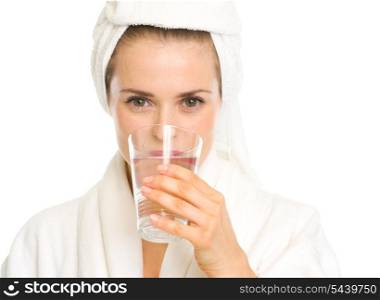 Young woman in bathrobe drinking pure water