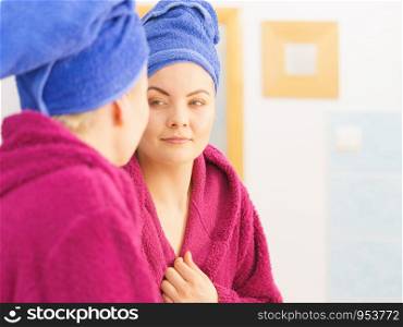 Young woman in bathroom after taking shower feeling clean and relaxed wearing towel and bathrobe. Woman in towel after shower