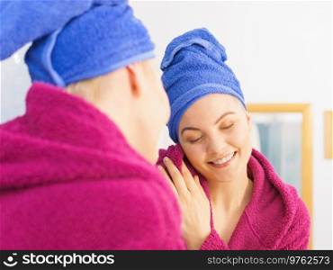 Young woman in bathroom after taking shower feeling clean and relaxed wearing towel and bathrobe. Woman in towel after shower