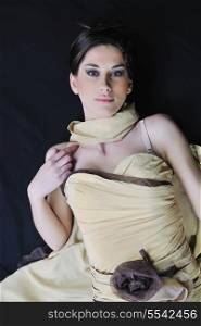 young woman in beautiful luxury dress in studio against black background in dark representing nightlife and fashion concept