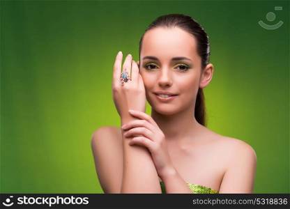 Young woman in beauty concept on green background