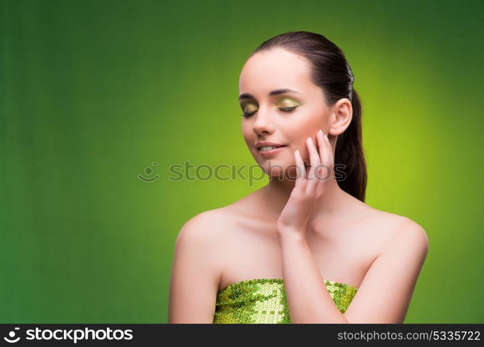 Young woman in beauty concept on green background