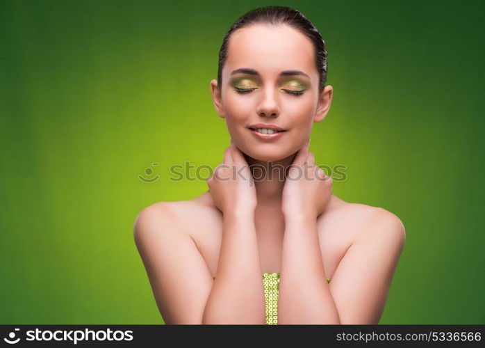 Young woman in beauty concept on green background