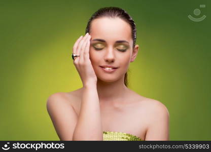 Young woman in beauty concept on green background