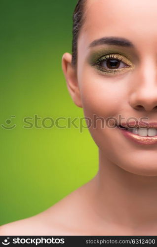 Young woman in beauty concept on green background