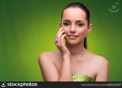 Young woman in beauty concept on green background