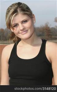Young woman in black tank top outside at jogging track.