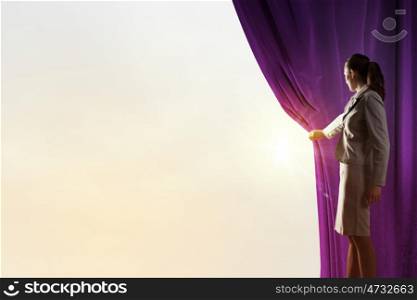 Young woman in business suit opening color curtain of stage. Open new opportunities