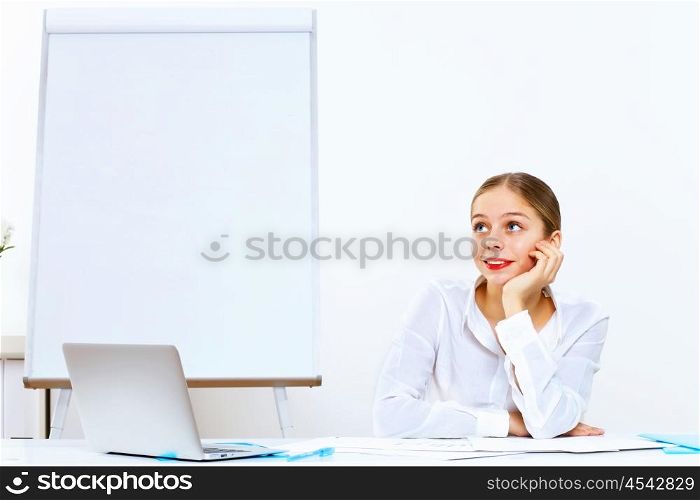Young woman in business wear generating ideas in office