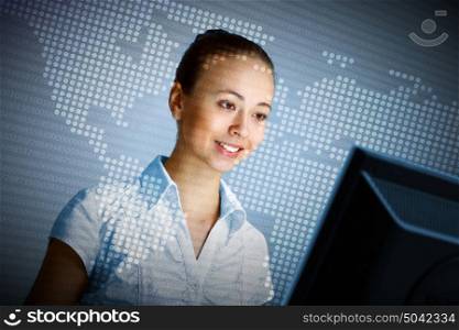 Young woman in business wear in headset working with computer