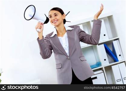 Young woman in business wear with megaphone in office