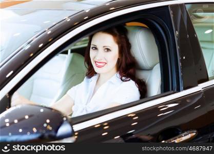 Young woman in car. Attractive young woman sitting in car in car center
