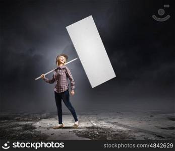 Young woman in casual carrying white blank banner. Girl with banner