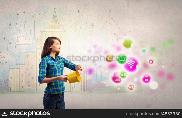 Young woman in casual holding yellow bucket with icons