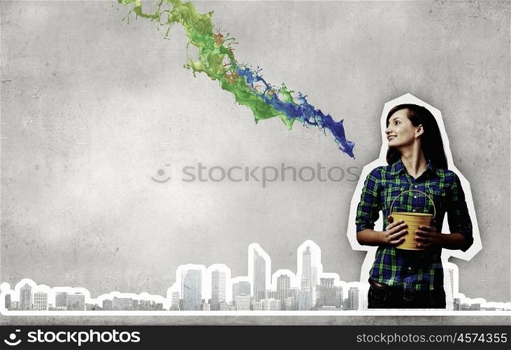 Young woman in casual holding yellow bucket with splashes. Add some color