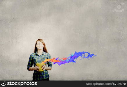 Young woman in casual holding yellow bucket with splashes. Add some color