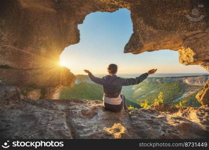 Young woman in cave mountain. Conceptual scene.