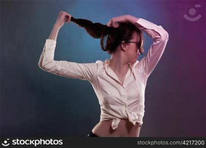 young woman in colorful light pulling her hair. young woman in colorful disco light pulling her hair