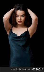 young woman in dark blue dress dress. on a black isolated background.she touches her face with her hand, touches her hair.. young woman in dark blue dress dress. on a black isolated background.she touches her face with her hand, touches her hair