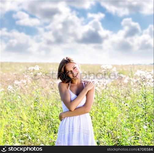 Young woman in dress walking on a meadow